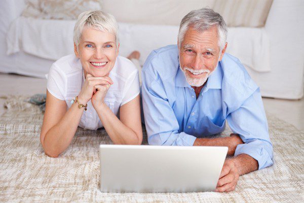 Happy senior couple lying down with a laptop, The Myndset Digital Marketing and Brand Strategy